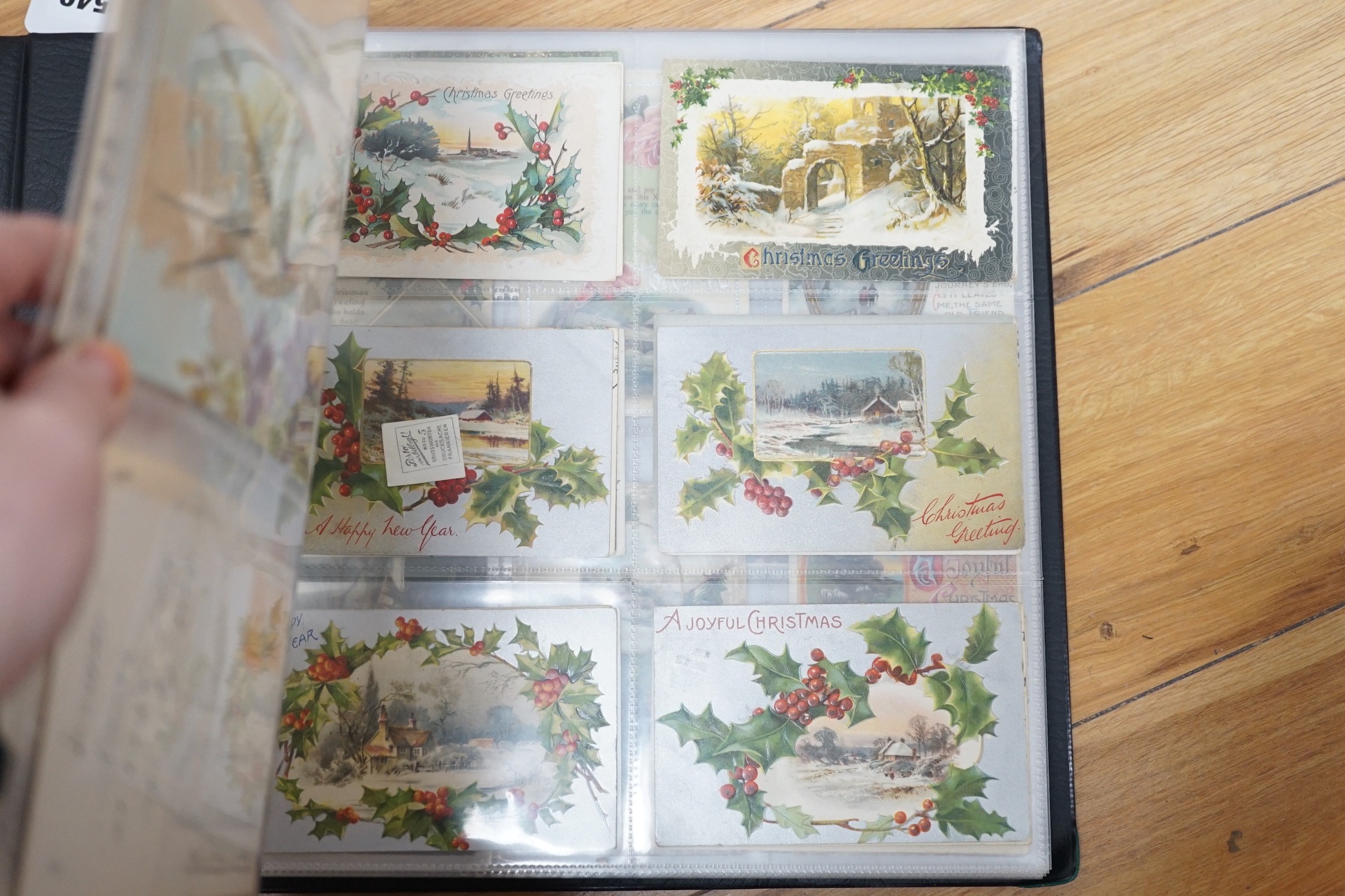 A selection of early 20th century postcards in an album, to include novelty, Christmas, Happy New Year, German, French, Paris, English locations, including Brighton, etc.